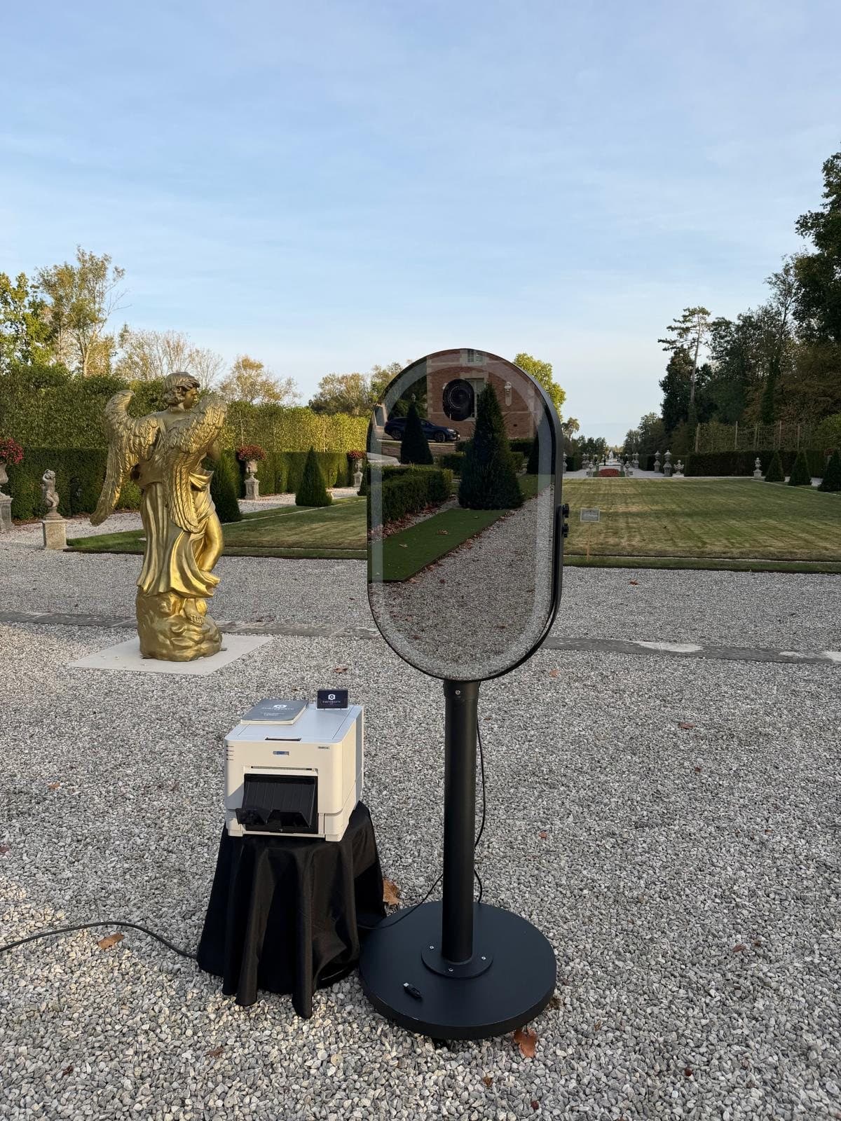 Photobooth miroir et son imprimante DNP installés dans les jardins d'un château, près d'une statue dorée